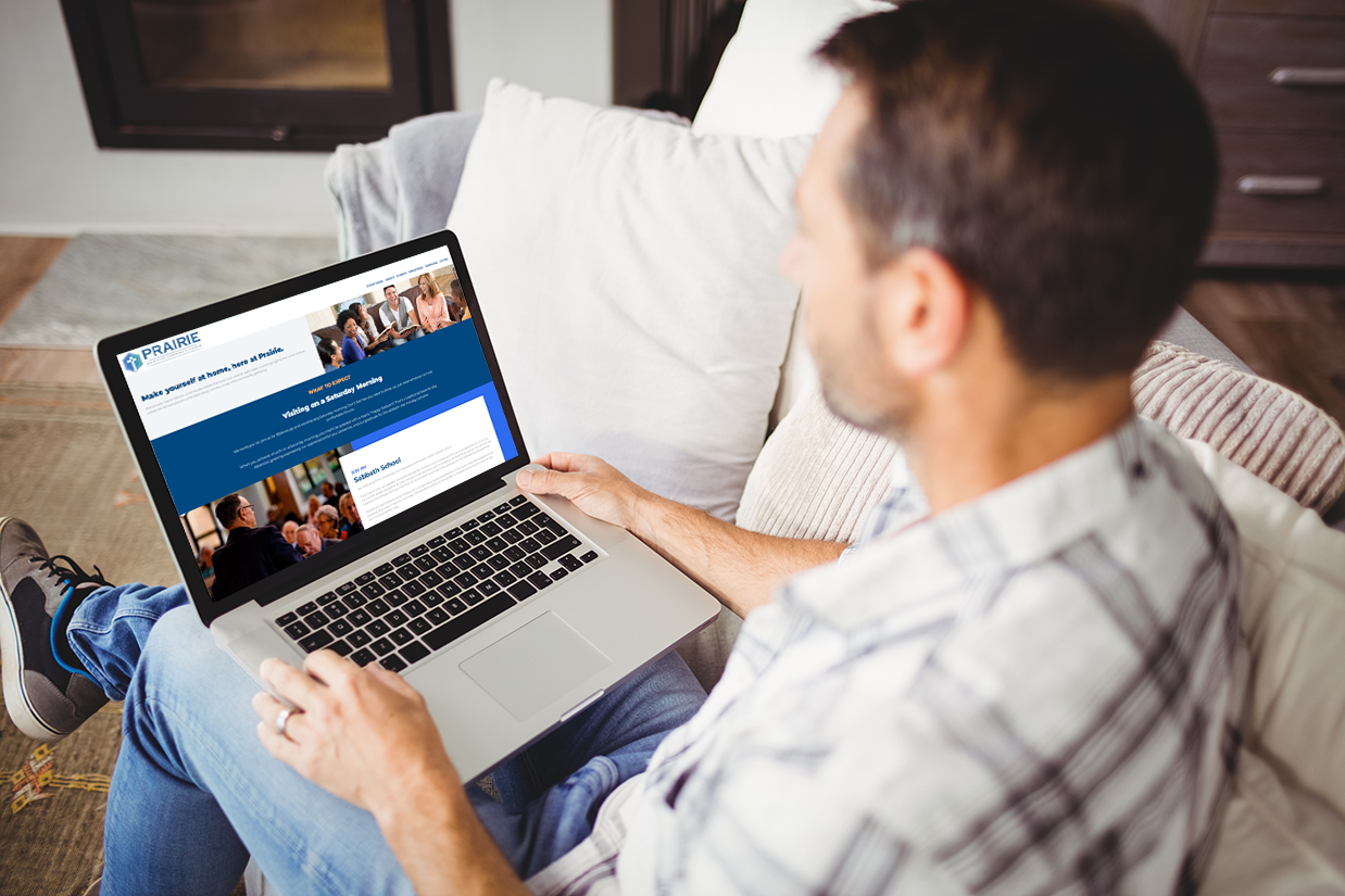 man looking at his evangelism website on a laptop